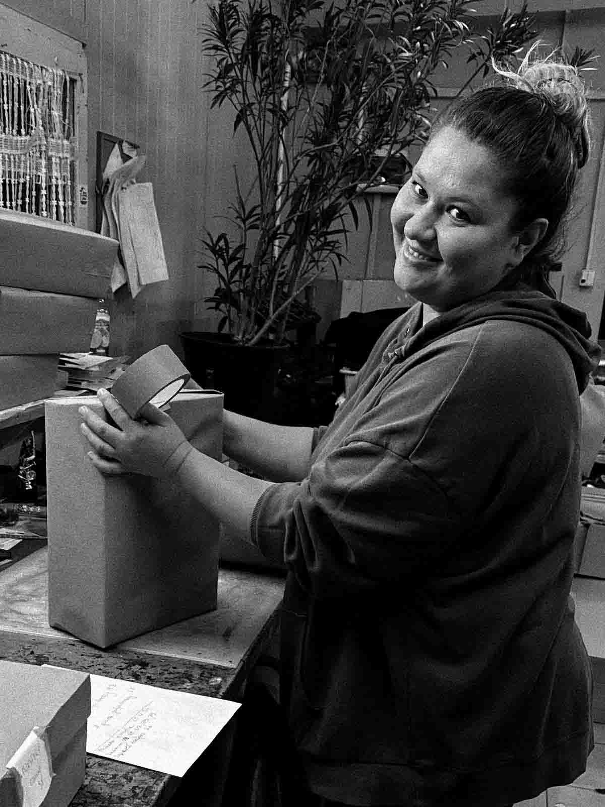 woman packing a package to send shoes bohem